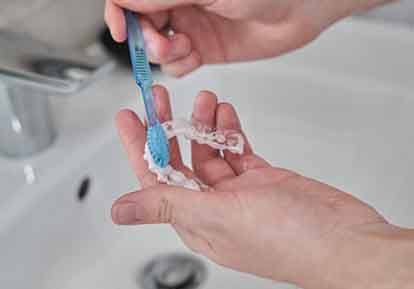 Patient cleaning aligner with toothbrush in sink